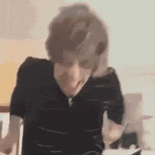 a man in a black shirt is making a funny face .