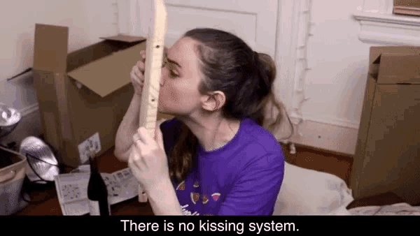 a woman in a purple shirt kisses a piece of wood