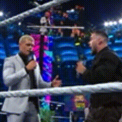 a man in a suit is talking into a microphone in a boxing ring