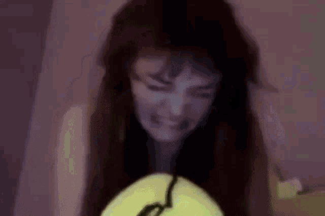 a close up of a person 's head with a yellow tennis ball in it .