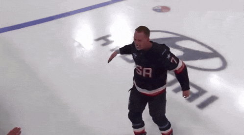 a man wearing a sa jersey stands on a ice rink