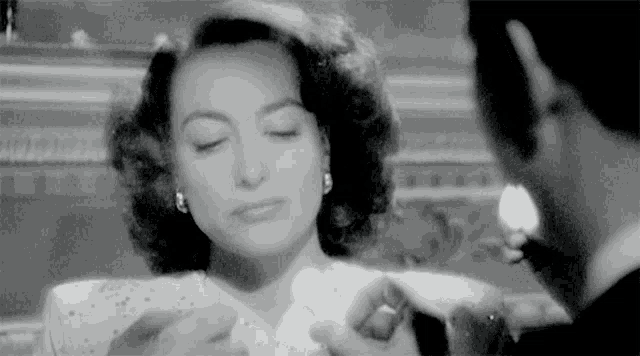 a black and white photo of a woman and a man looking at each other .