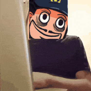a person is typing on a laptop with a picture of a cartoon character behind them