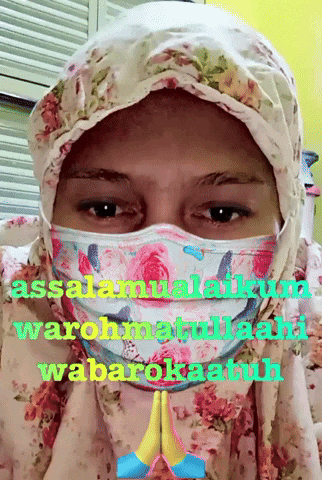 a woman wearing a floral hijab and a face mask says assalamualaikum warohmatullah wabarokatuh