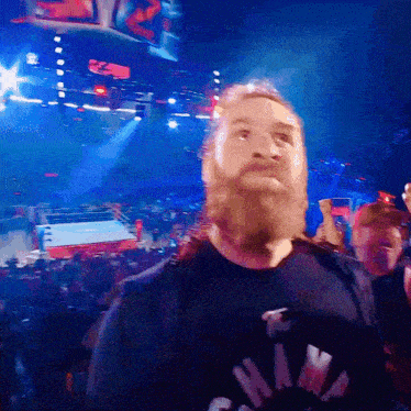 a man with a beard wearing a shirt that says ' raw '