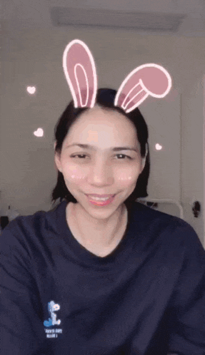 a woman wearing bunny ears is smiling and wearing a shirt that says tokyo city