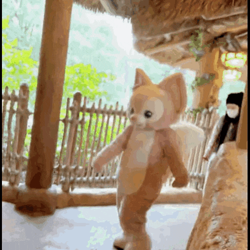 a stuffed animal dressed as a cat is walking in a room .