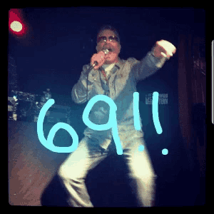 a man singing into a microphone with the number 69:11 written on the stage