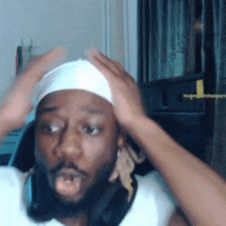 a man wearing headphones and a headband is holding his head