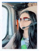 a woman wearing sunglasses and a headset is sitting in a car .