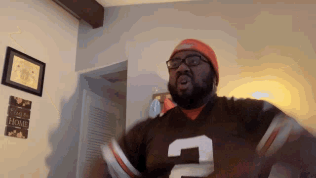 a man wearing a brown jersey with the number 2 on the front