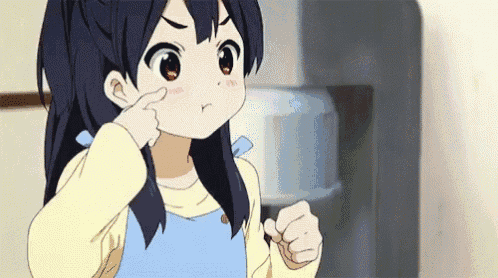 a little girl is pointing at her nose while making a funny face .