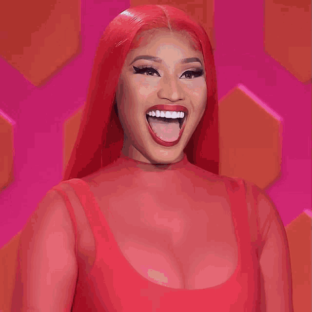 a woman with red hair is smiling with the name nicki minaj behind her