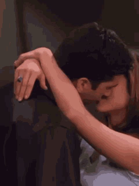 a man and a woman are kissing and hugging each other . the woman has a ring on her finger .