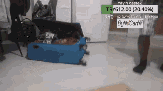 a blue suitcase is sitting on the floor next to a sign that says bynogame