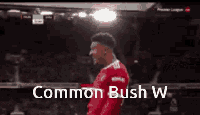 a soccer player in a red jersey with the words " common bush w " on the bottom