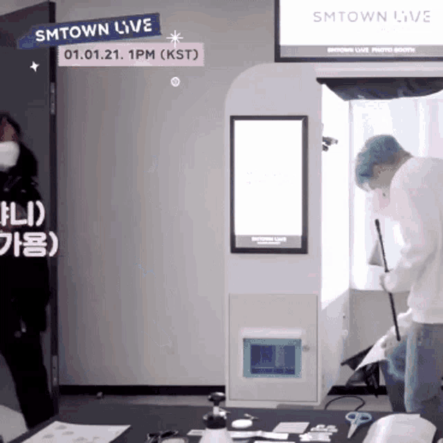 a man is standing in front of a smtown live sign