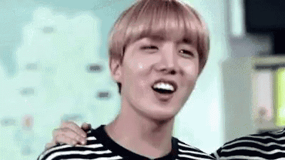 a young man in a striped shirt is smiling and laughing .