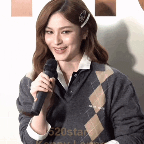 a woman is holding a microphone in front of 520star