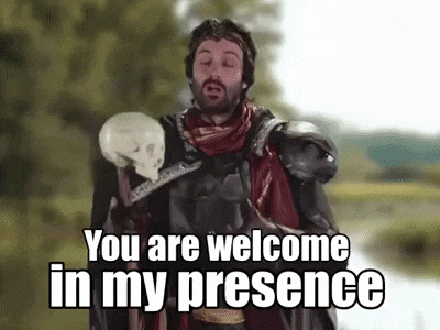 a man in armor is holding a skull and a cane .
