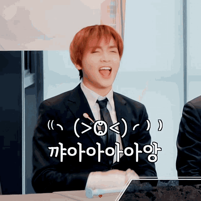 a man in a suit and tie is laughing with a foreign language behind him