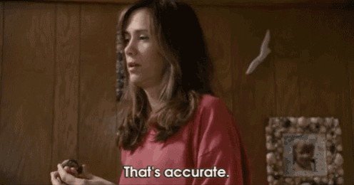 a woman in a pink shirt says that 's accurate in front of a picture frame .