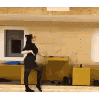 a woman is dancing in a room with a wooden wall .
