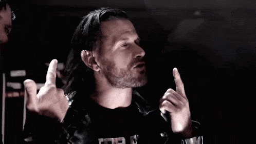 two men in leather jackets are giving the middle finger in a dark room
