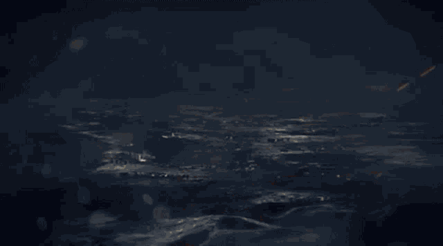 a lightning bolt is shining over a body of water in the dark .