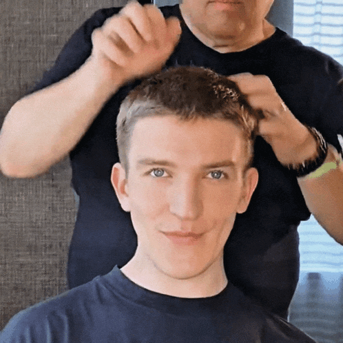 a man is getting his hair cut by a woman