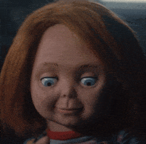 a close up of a doll with red hair holding a red apple