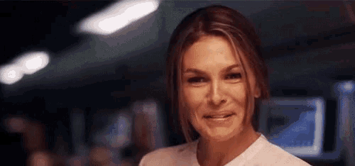 a close up of a woman smiling in a dark room .