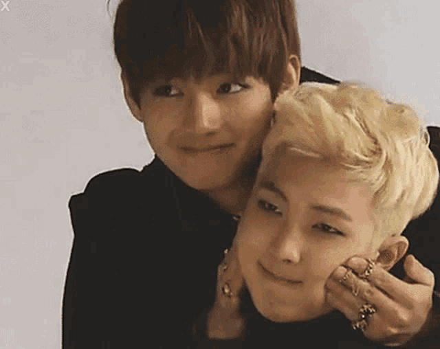two young men are hugging each other and one of them is touching the other 's face