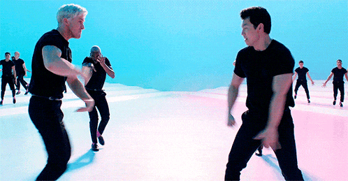 a group of men in black shirts are dancing in the air
