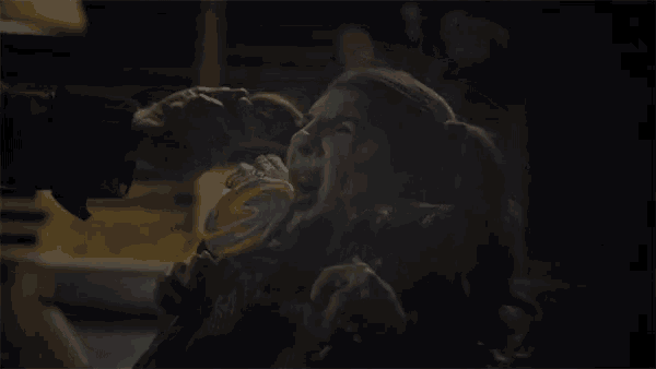 a woman is eating a colorful lollipop in the dark
