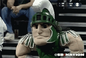 a spartan mascot is sitting on a bleacher in front of a cbs logo