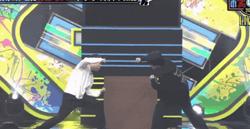 two men are fighting on a stage with a sign that says 90 on it