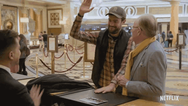 a man in a plaid shirt is giving a high five to another man in a suit in a netflix ad