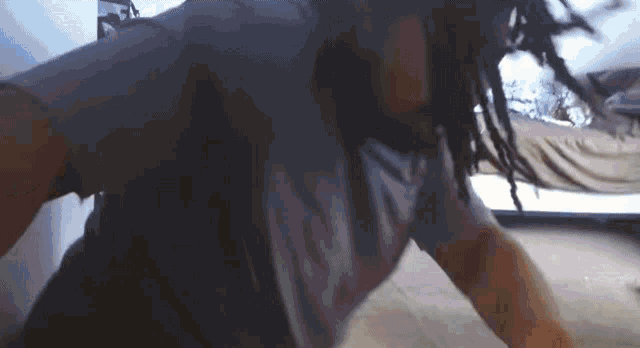 a man with dreadlocks is dancing in a dark room