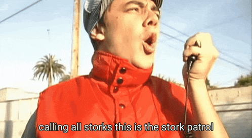 a man in a red vest is singing into a microphone with the words calling all storks this is the stork patrol below him