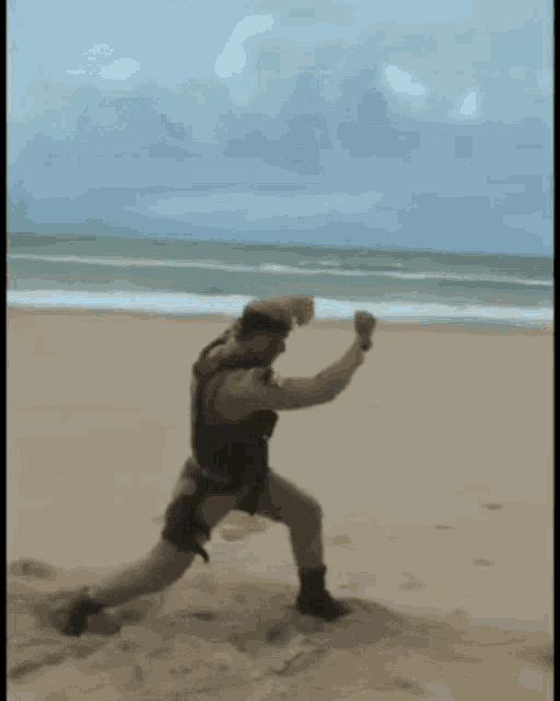 a man in a military uniform is running on the beach