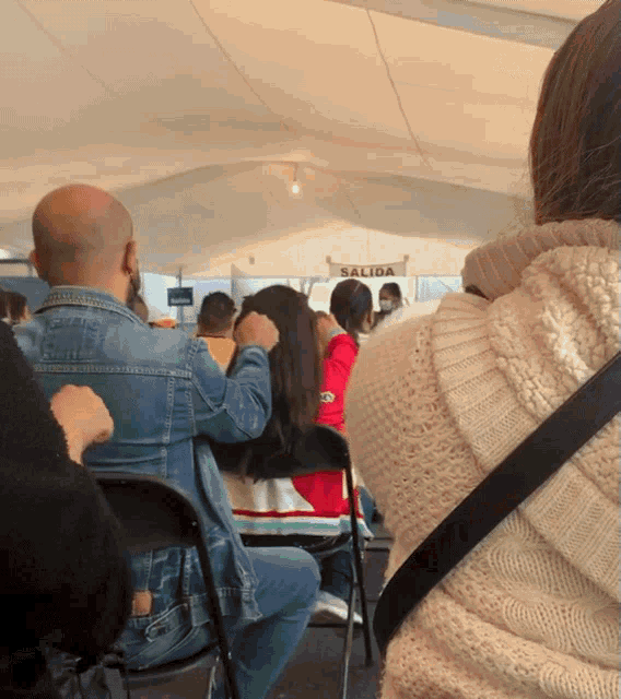 a group of people sitting under a tent with the word salida on it