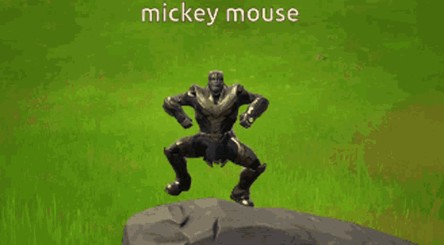 a video game character named mickey mouse is standing on a rock in the grass