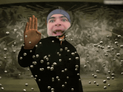 a man with a microphone on his head is surrounded by balls