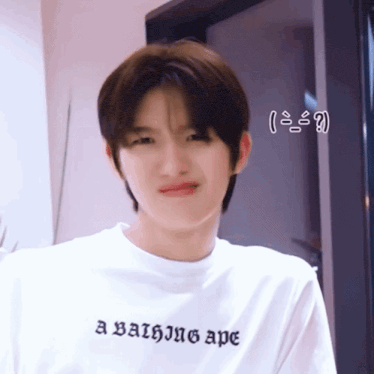 a young man wearing a bathing ape t-shirt making a funny face