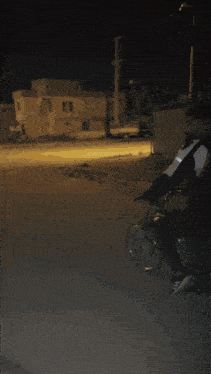 a man riding a motorcycle in front of a bin sign