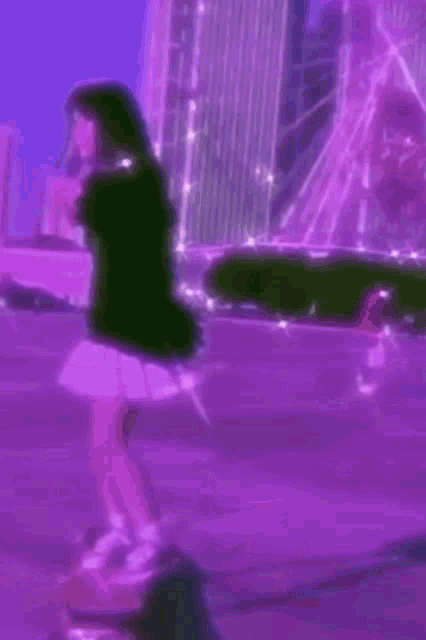 a girl is standing in front of a ferris wheel in a purple city .