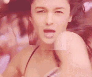 a woman in a bikini is sticking her tongue out while dancing .