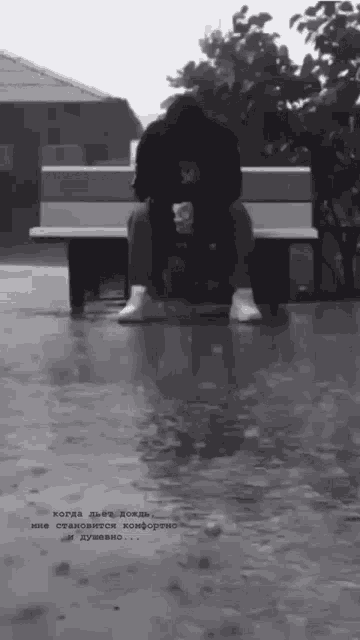 a black and white photo of a person sitting on a bench