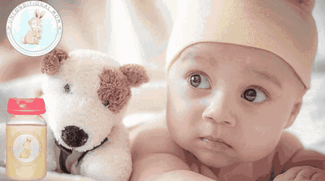 a baby is laying next to a stuffed dog and a bottle of breast milk